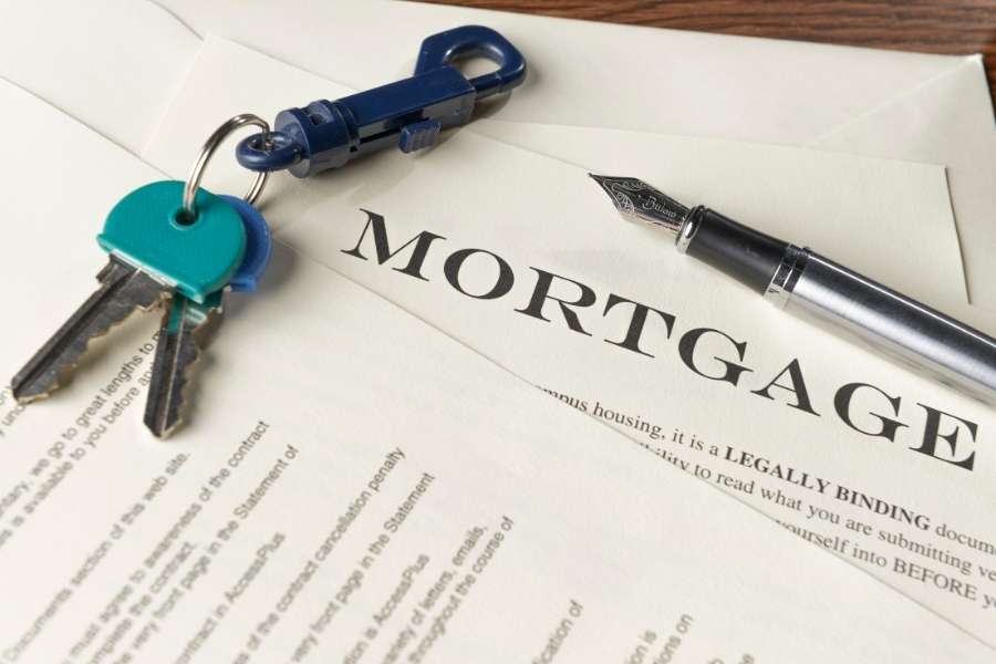 Un document de prêt immobilier avec un stylo et des clés de maison, symbolisant la capacité d’emprunt nécessaire.